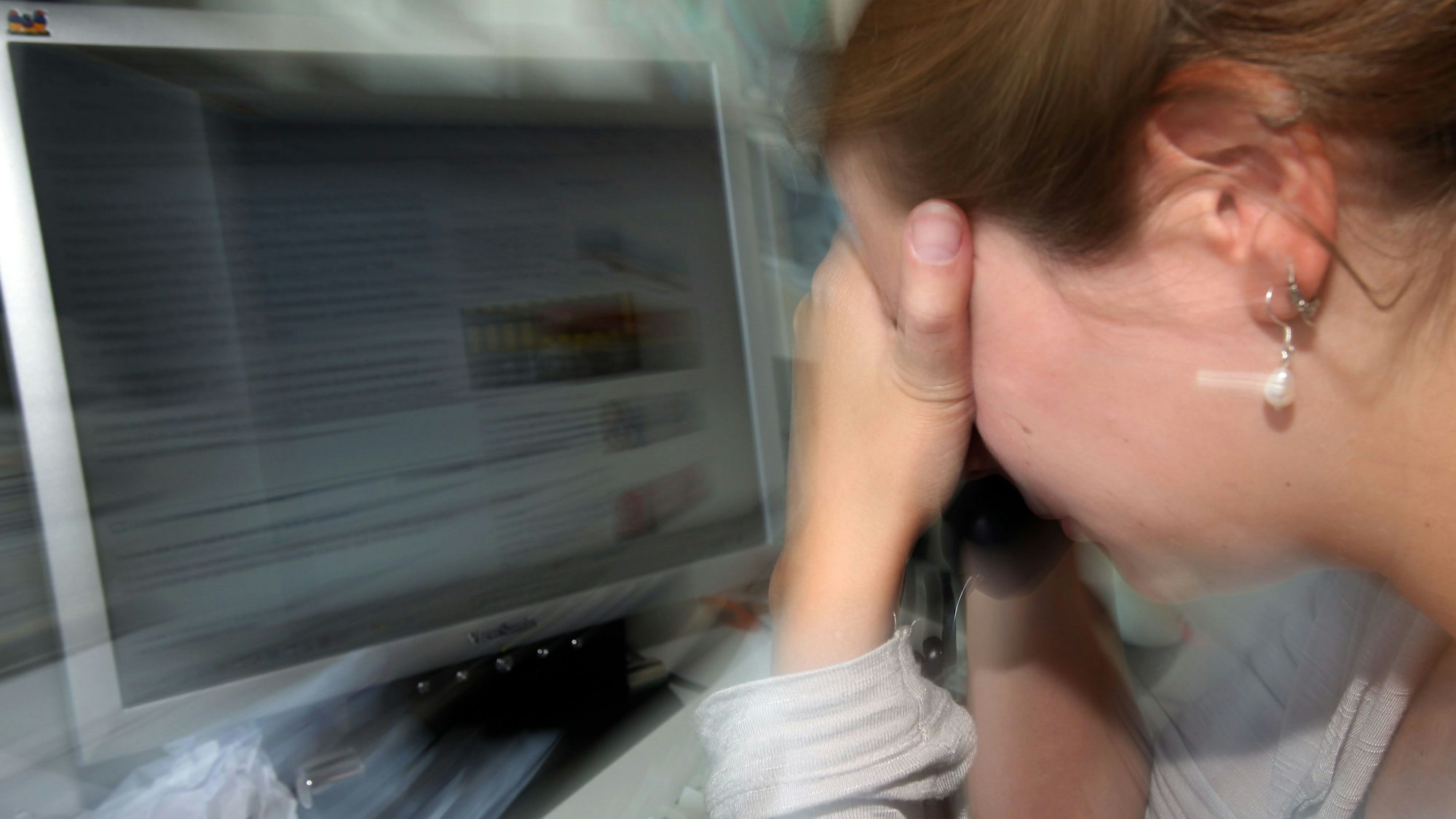 Eine depressive Frau an ihrem Arbeitsplatz (Symbolfoto).
