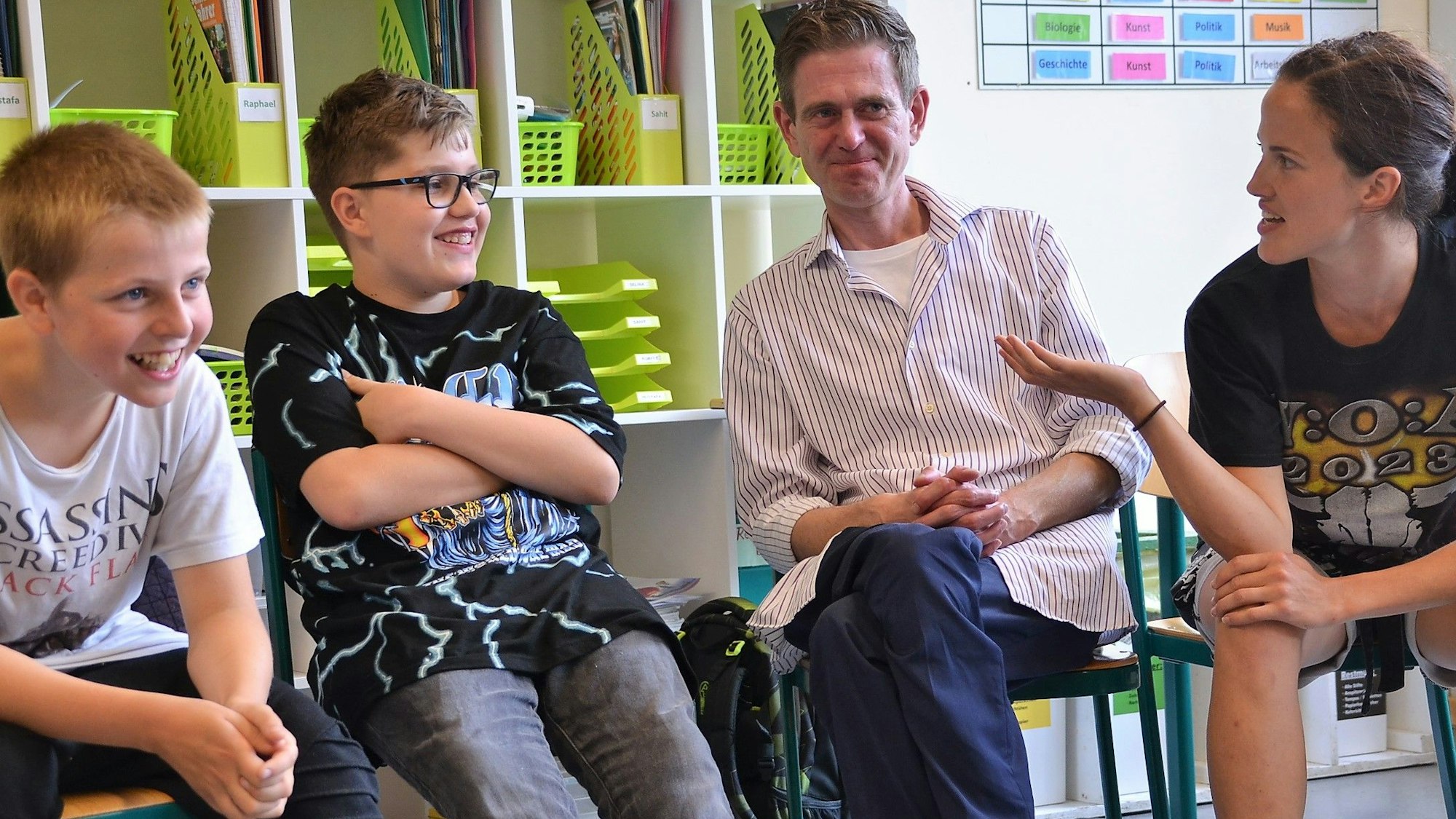 Die beiden Schauspieler Salina Sarhage (v.r.) und Henrik Fockel leiten an der Roseggerschule in Waldbröl einen Kurs, der Schülerinnen und Schüler gegen Mobbing wappnen soll. Hier sitzen sie mit den Kindern in einer Runde und diskutieren über ein Rollenspiel.