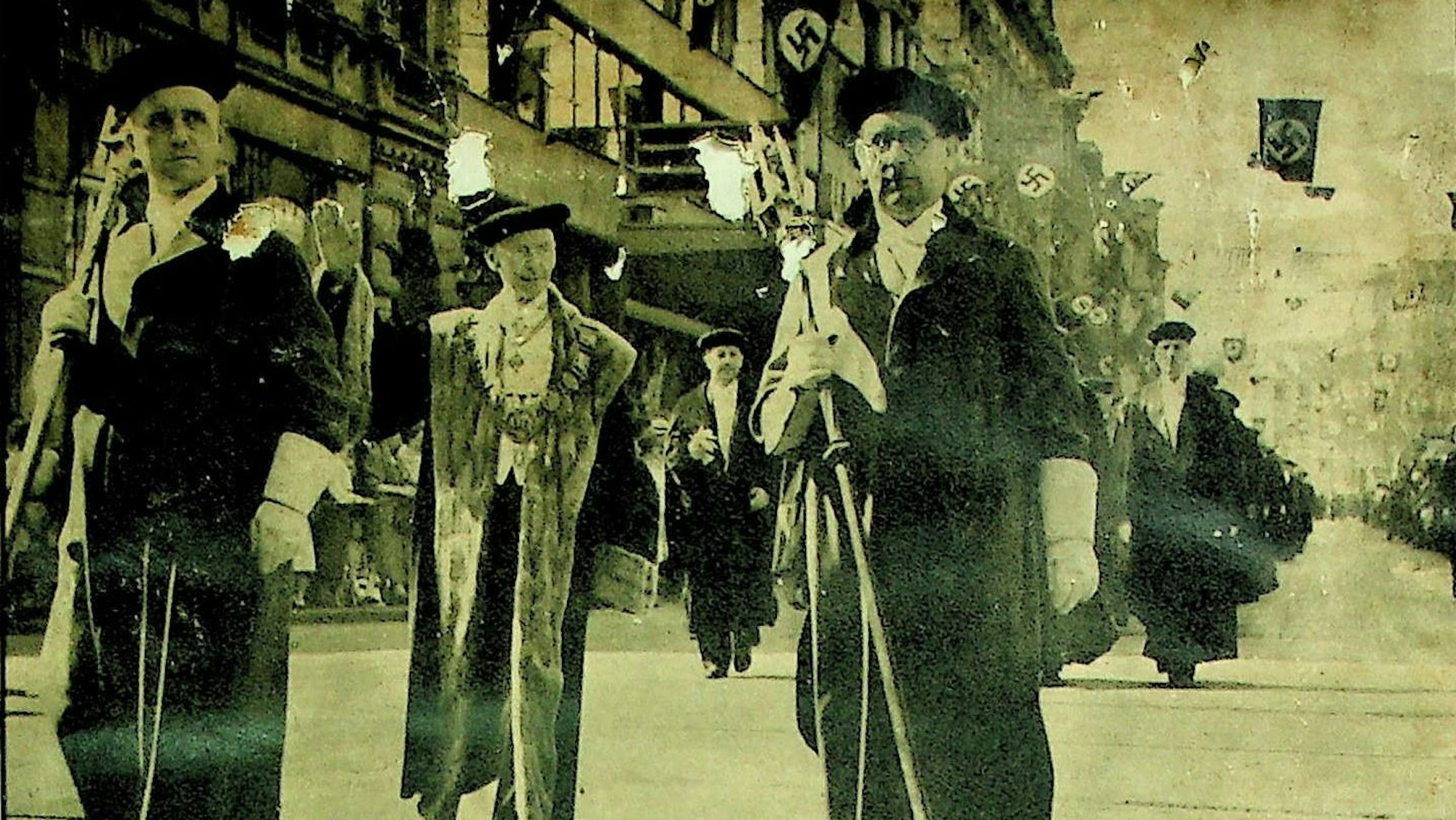 Männer in Mänteln und NSDAP-Fahnen (Sepia-Aufnahme)