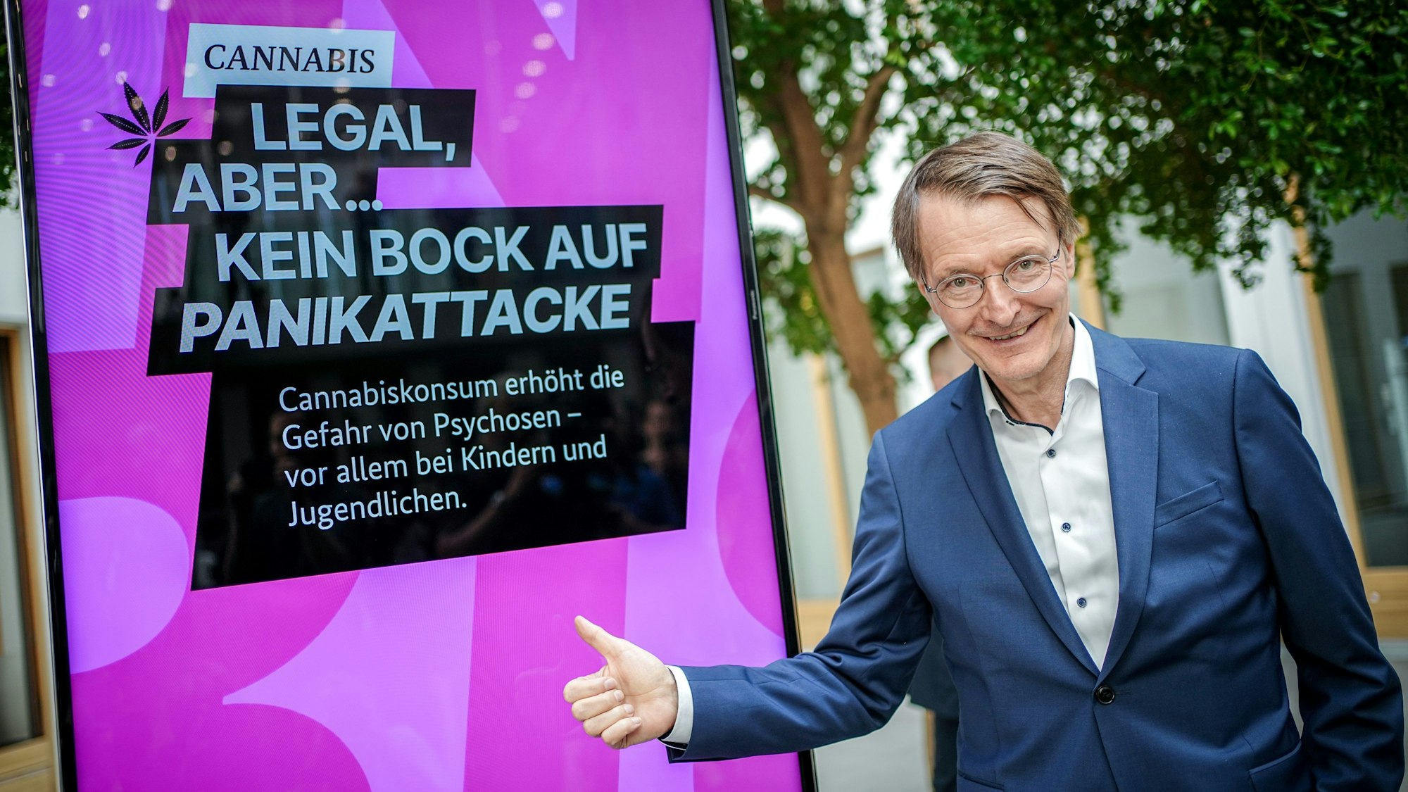Karl Lauterbach (SPD), Bundesminister für Gesundheit, gibt neben einem Plakat mit der Aufschrift „Cannabis. Legal, aber ... kein Bock auf Panikattacke“ einen Daumen nach oben.