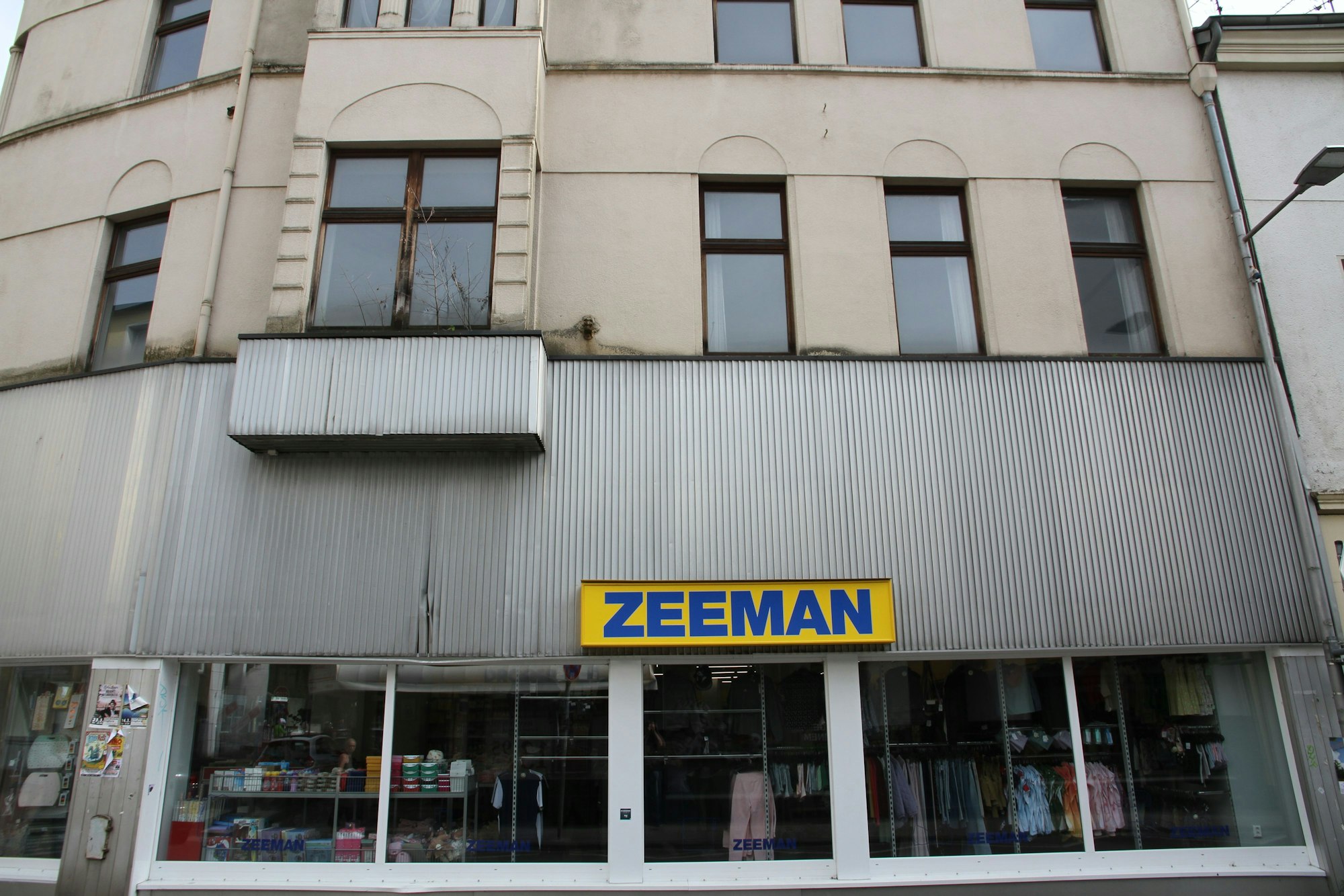 Geschäftshaus mit einer hellgrauen Wellblechverkleidung an der Bahnhofstraße in Siegburg