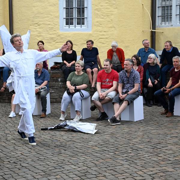 Eine Frau und ein Mann tanzen vor Zuschauern auf dem Hof von Schloss Homburg.
