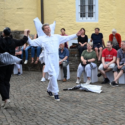 Eine Frau und ein Mann tanzen vor Zuschauern auf dem Hof von Schloss Homburg.