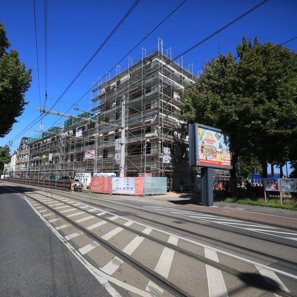 An der Siegburger Straße in Poll steht ein großes mehrstöckiges Gebäude. Der Rohbau ist noch eingerüstet.