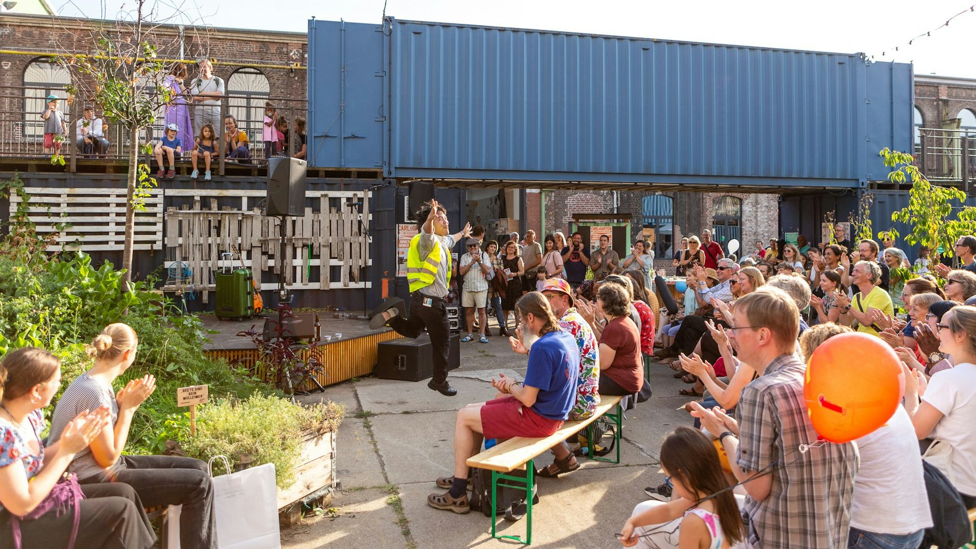 Besucher auf Sitzbänken vor dem Depot des Schauspiels Köln