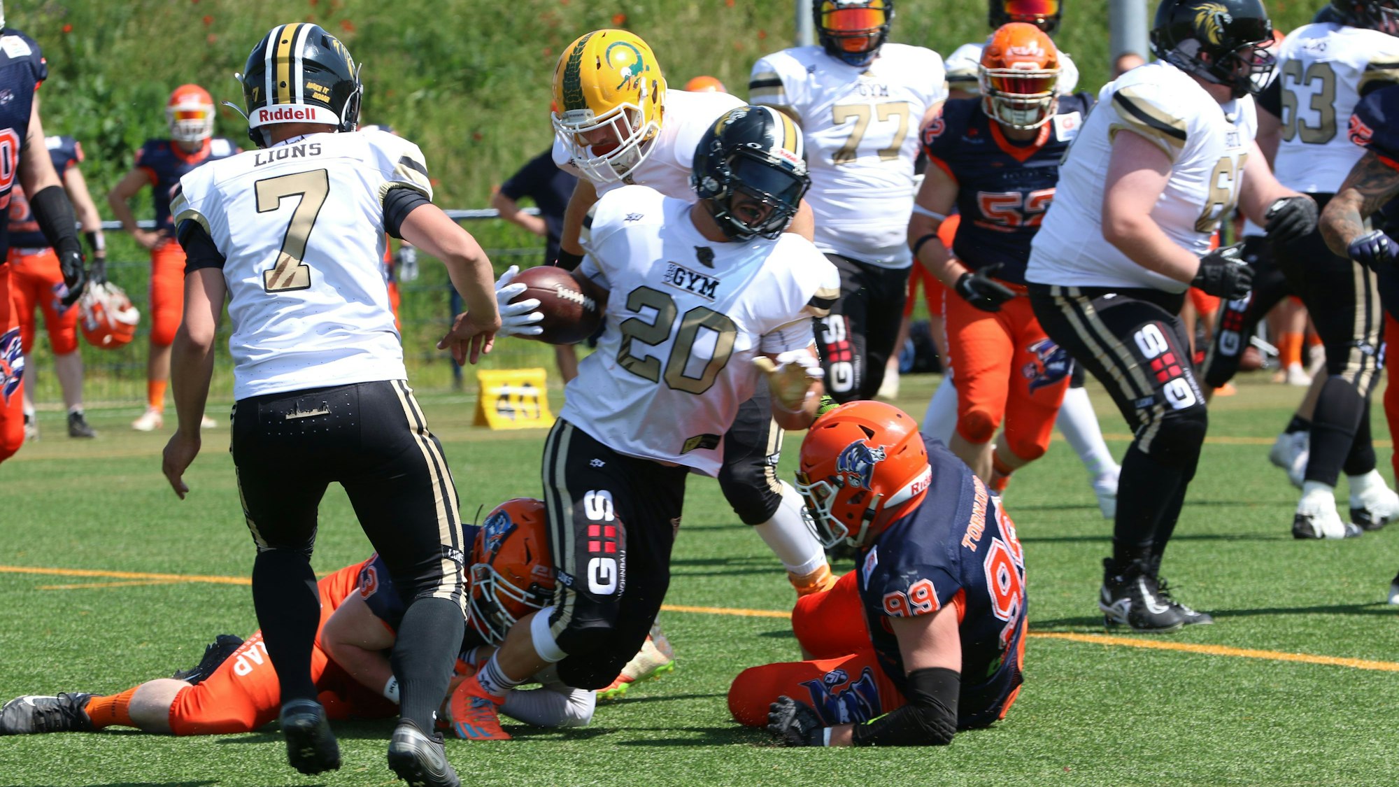 Ein Footballer der Euskirchen Lions wird von gegnerischen Spielern zu Fall gebracht.