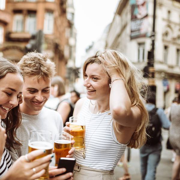 Junge Menschen trinken Bier bei einem Straßenfest.