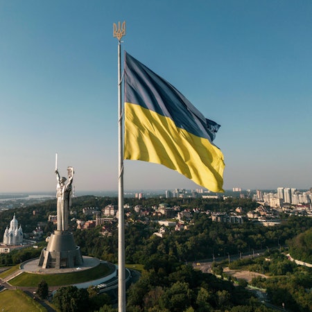 Eine ukrainische Flagge weht nahe dem Denkmal von „Mutter Heimat“ in Kiew im Wind. (Symbolbild)