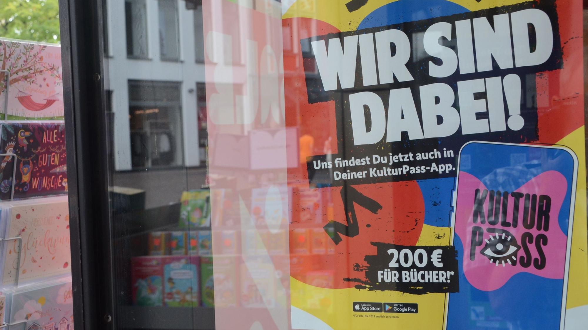 Auf einem bunten Plakat im Schaufenster einer Buchhandlung steht „Wir sind dabei“.