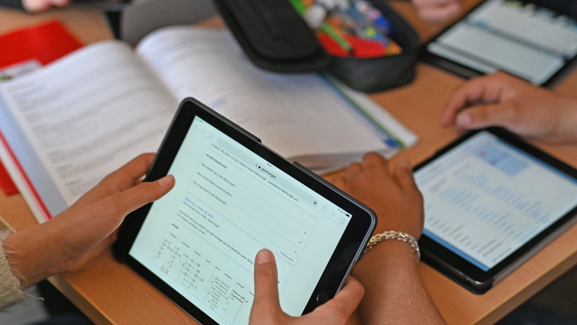 Schüler halten Tablets in der Hand.