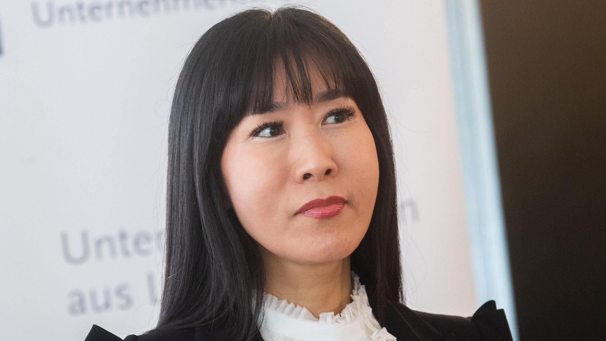 Soyeon Schröder-Kim hält einen Vortrag. Sie ist im Porträt zu sehen, trägt eine weiße Bluse und ein schwarzes Jackett.