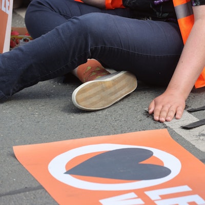 Aktivisten der «Letzten Generation» sind zu sehen, sie blockieren eine Straße, auf der sie sich festgeklebt haben.