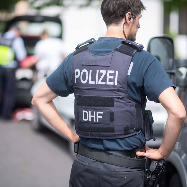 Ein Polizeibeamter spricht während einer Verkehrskontrolle mit einem Autofahrer.