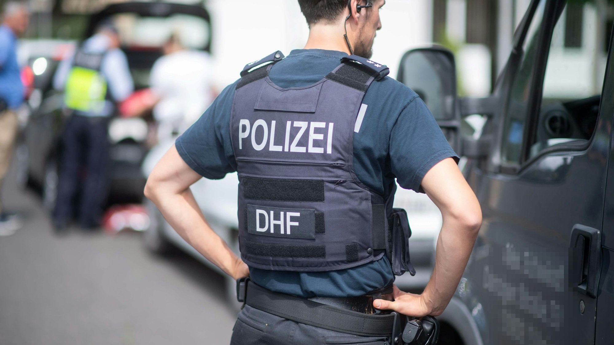 Ein Polizeibeamter spricht während einer Verkehrskontrolle mit einem Autofahrer.