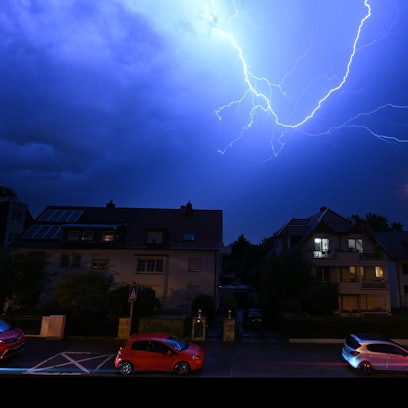 Blitze entladen sich am Abendhimmel in Frankfurt. Dort musste wegen der heftigen Regenfälle eine Landebahn des Flughafens zeitweise gesperrt werden. Zahlreiche Flüge fielen aus.