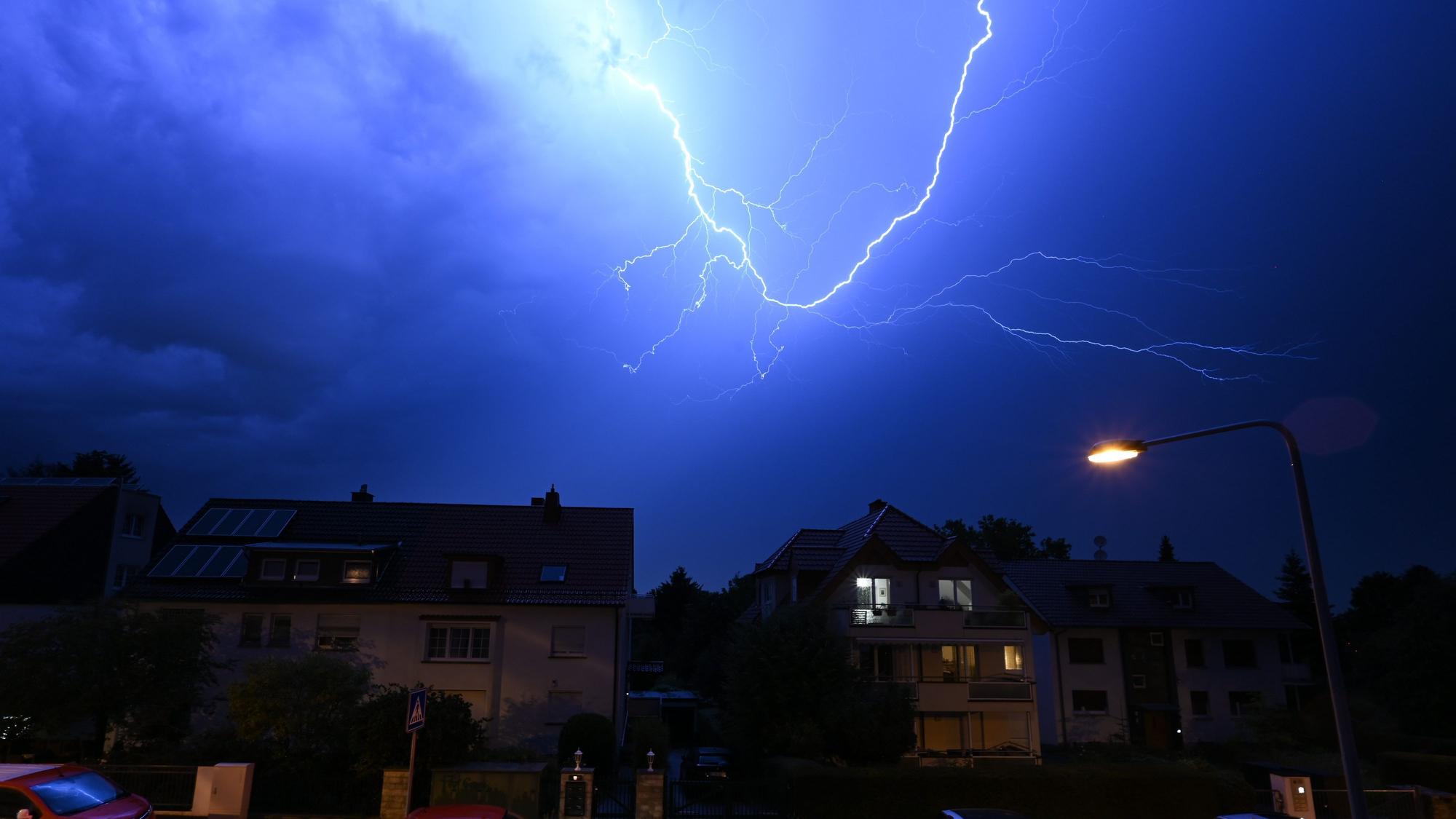 Blitze entladen sich am Abendhimmel in Frankfurt. Dort musste wegen der heftigen Regenfälle eine Landebahn des Flughafens zeitweise gesperrt werden. Zahlreiche Flüge fielen aus.