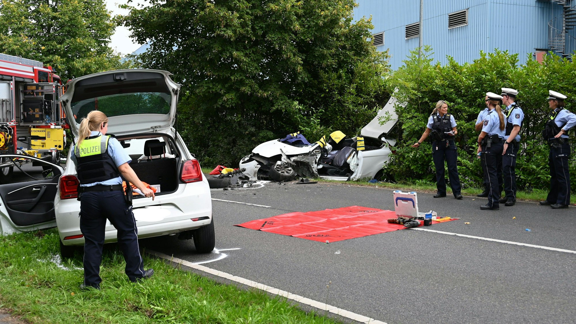 Polizisten vor einem Autowrack an der Bellerstraße.