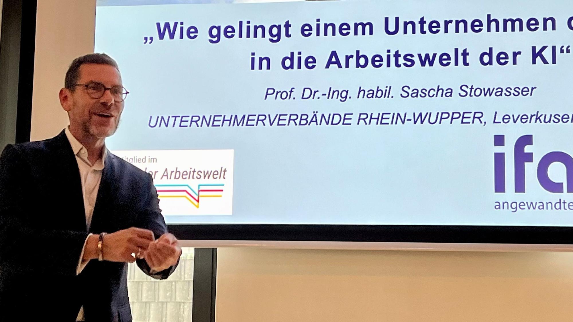 Sascha Stowasser, Chef des Instituts für Angewandte Arbeitswissenschaft, steht vor einer Folie.