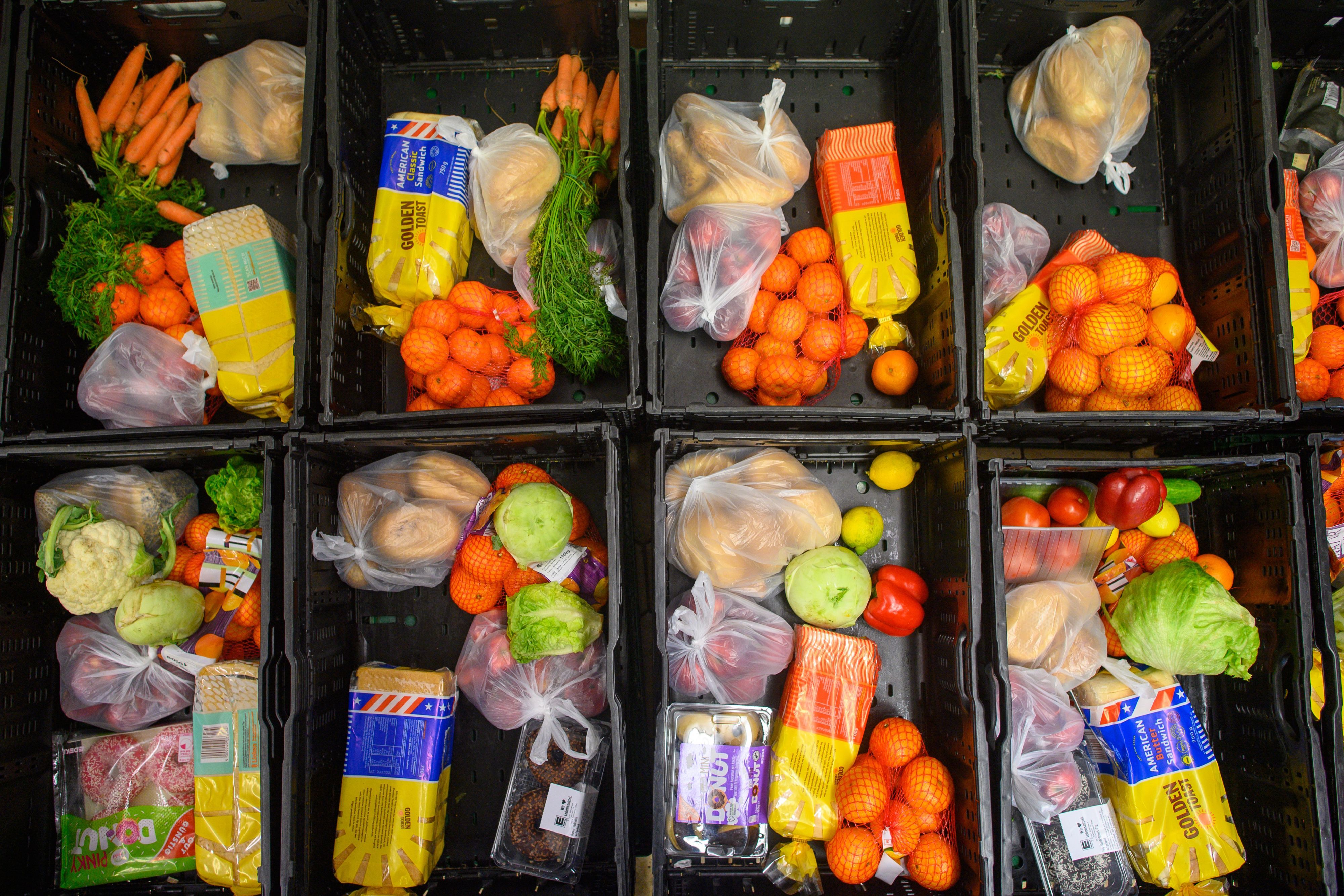 Abgepackt in große Plastikkörbe warten verschiedene Lebensmittel wie Obst, Gemüse und Brot auf die Verteilung an Bedürftige.