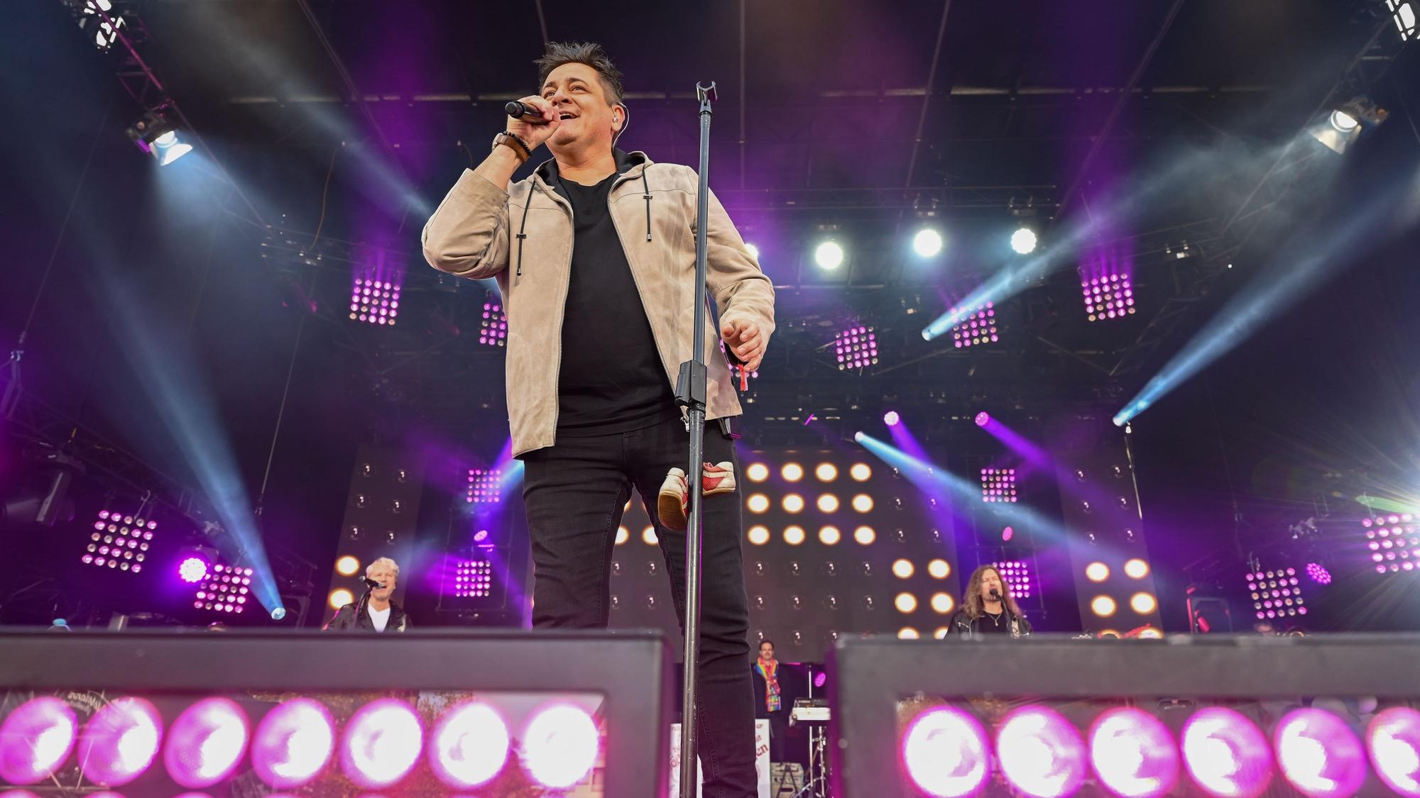Micky Nauber steht auf der Bühne und singt.