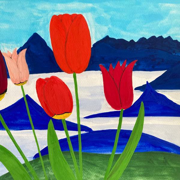 Rote Tulpen stehen vor einer blau-weißen Bergkulisse.