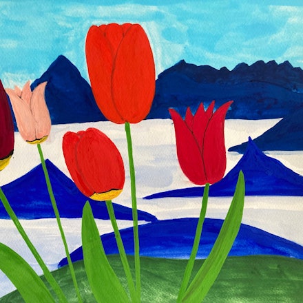 Rote Tulpen stehen vor einer blau-weißen Bergkulisse.