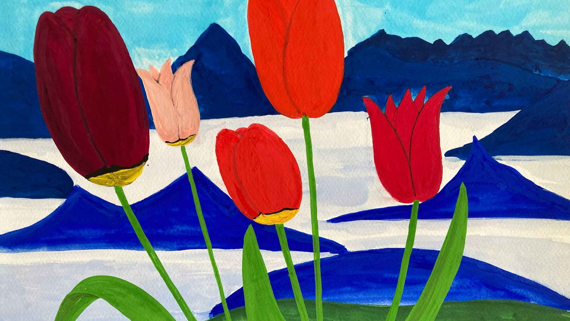 Rote Tulpen stehen vor einer blau-weißen Bergkulisse.
