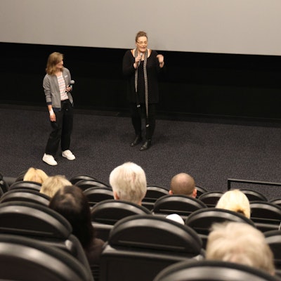 In einem der Säle des Gummersbacher Kinocenters Seven stehen Marie Brück (r.) und Moderatorin Nadine Lindörfer vom Netzwerk gegen Rechts vor der dunklen Leinwand und sprechen über Brücks langen und schmerzhaften Weg vom Mann zur Frau.