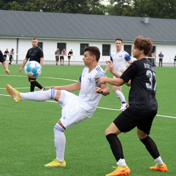 Ein Weilerswister Fußballspieler nimmt den Ball artistisch an und wird von einem Roitzheimger Gegenspieler bedrängt.