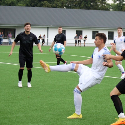 Ein Weilerswister Fußballspieler nimmt den Ball artistisch an und wird von einem Roitzheimger Gegenspieler bedrängt.