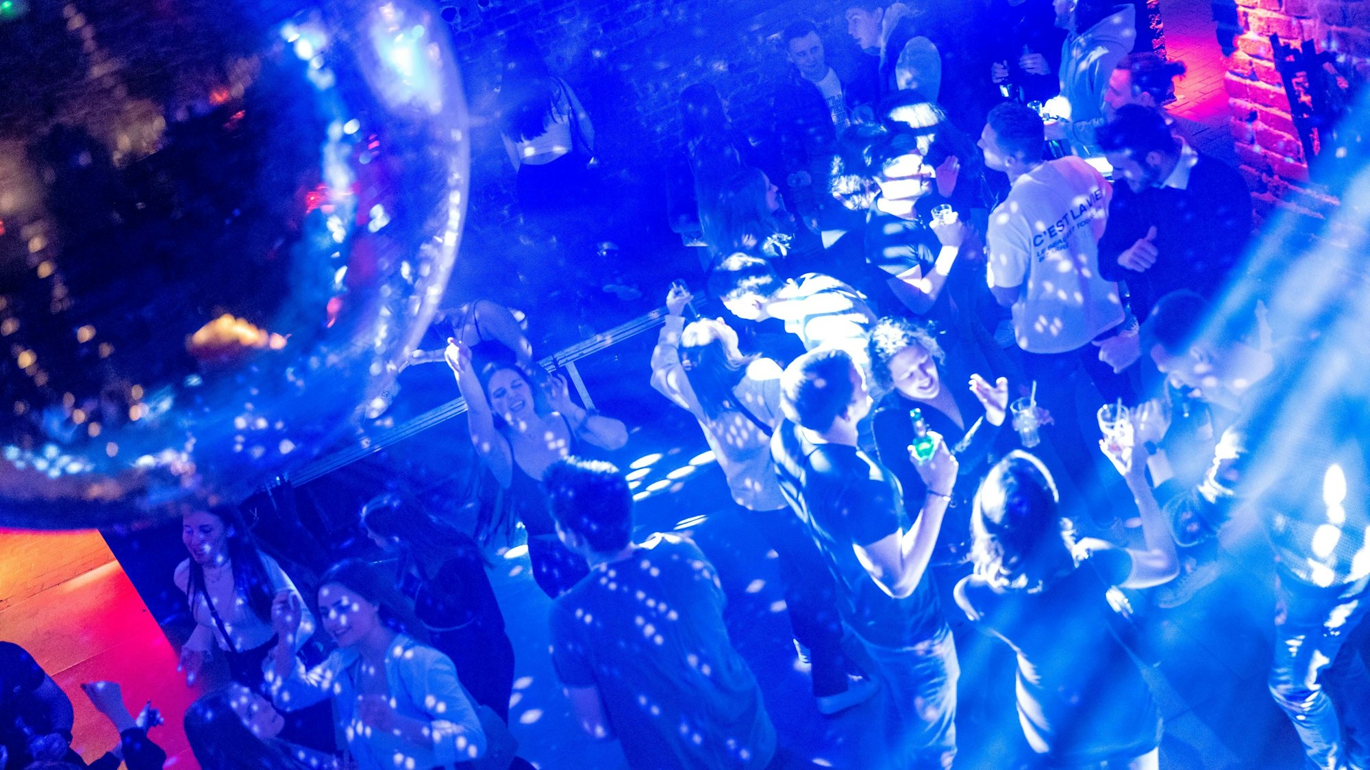 Junge Leute feiern und tanzen bei Discobeleuchtung im Club Roonburg.