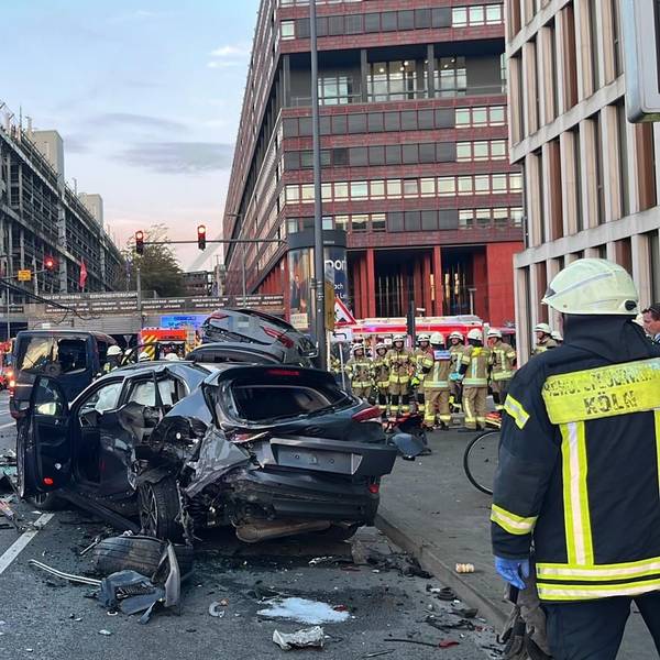 Einsatzkräfte an der Unfallstelle mit einem Autowrack in Deutz