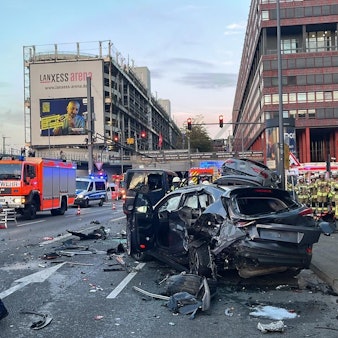 Einsatzkräfte an der Unfallstelle mit einem Autowrack in Deutz