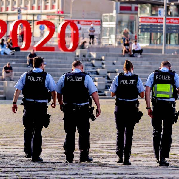 Vier Polizistinnen und Polizisten laufen über den Wiener Platz in Köln.