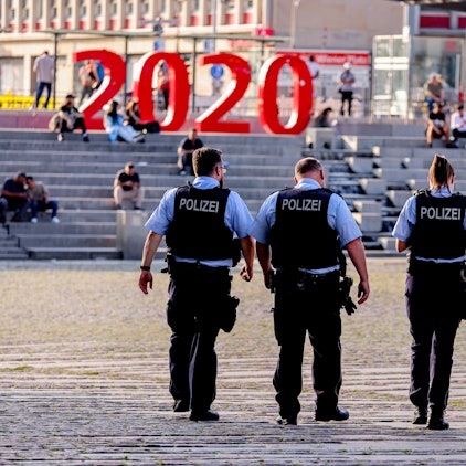Vier Polizistinnen und Polizisten laufen über den Wiener Platz in Köln.