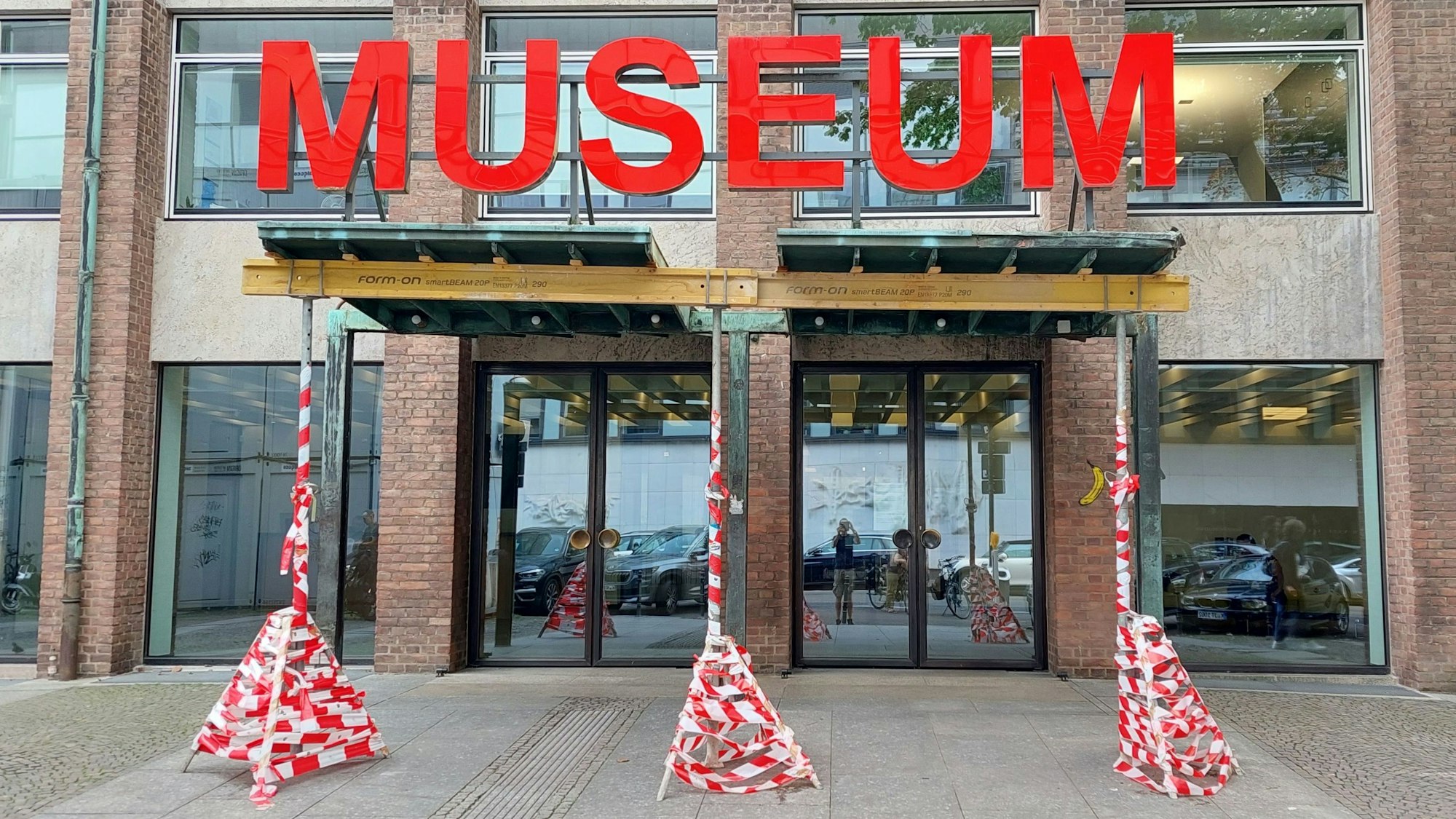 Drei Stützen mit Flatterband stehen unter dem Vordach des Museums.