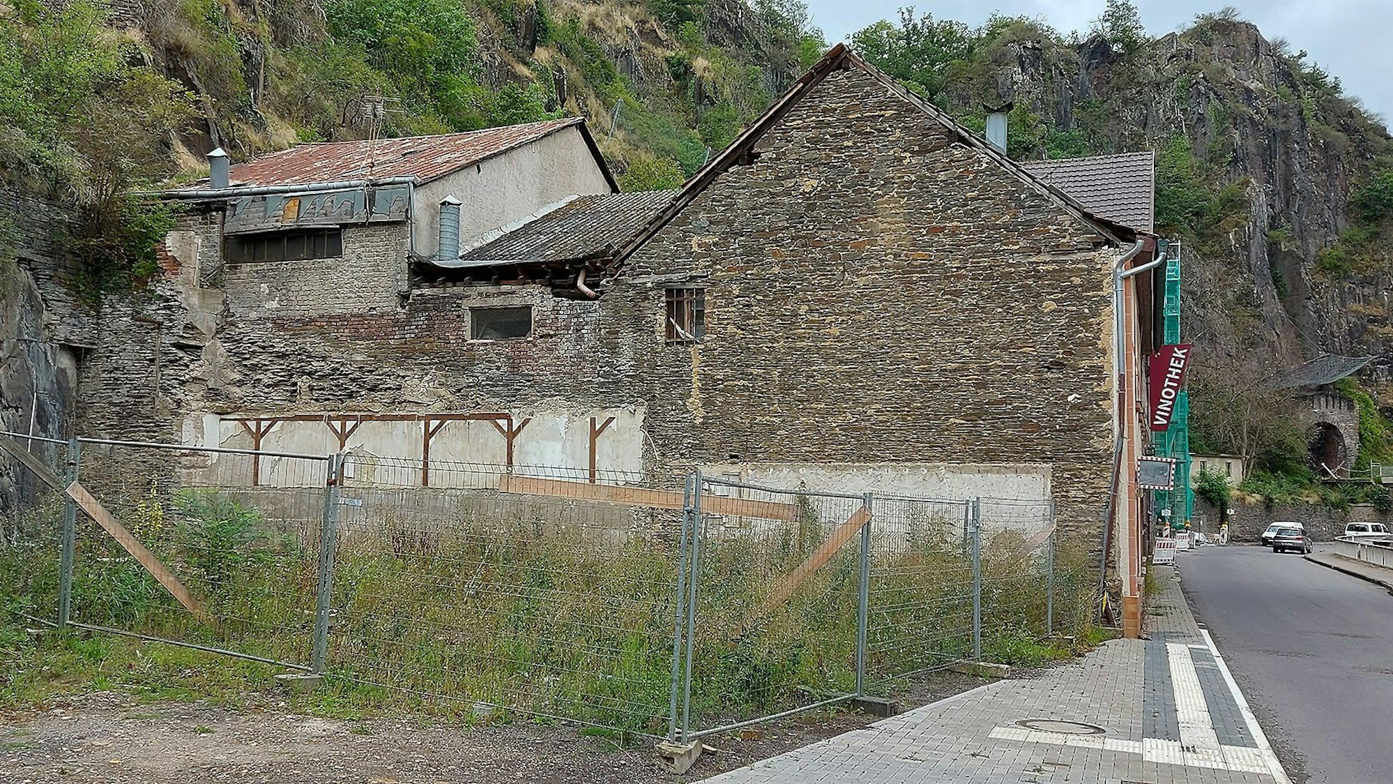 Das Bild zeigt ein eingezäuntes Grundstück, auf dem Gras wächst. Dort hat vorher ein Haus gestanden, das nach der Flutkatastrophe abgerissen werden musste.