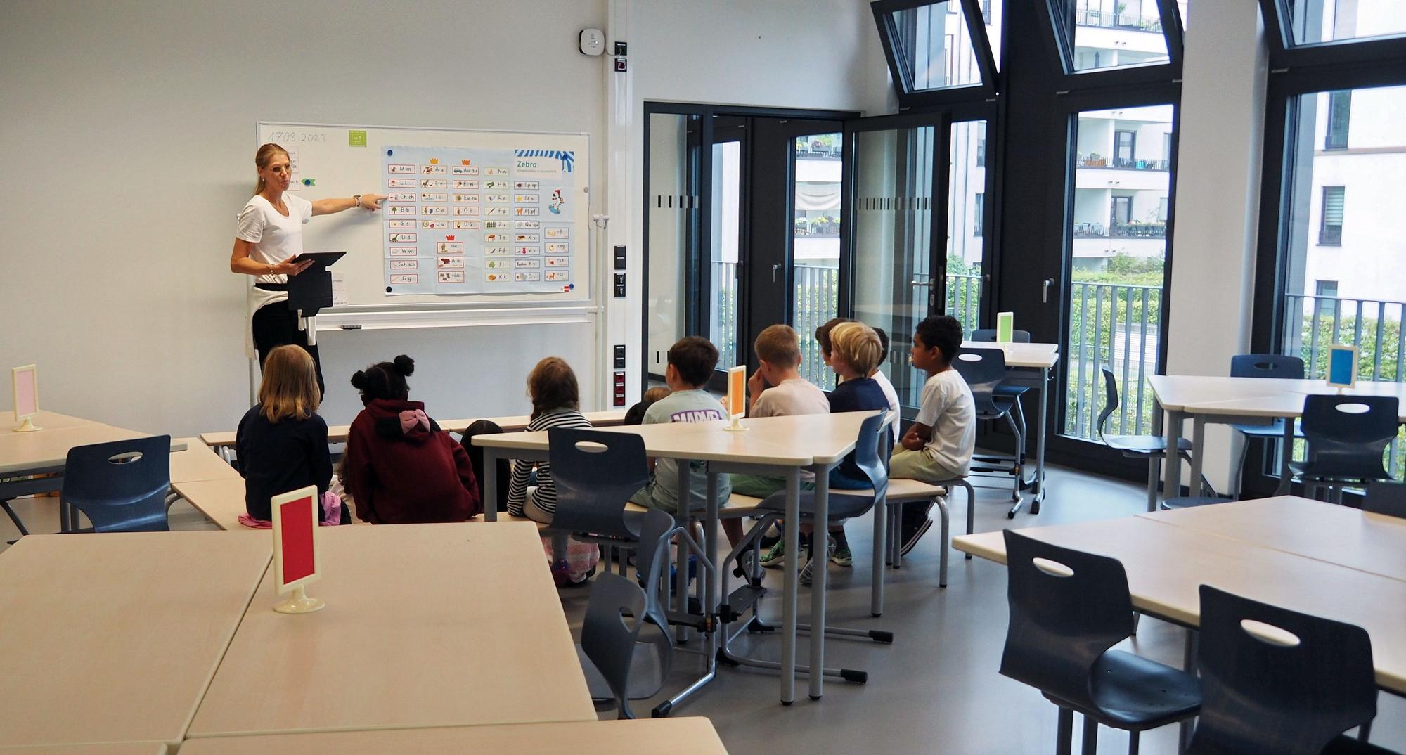 Anfang August ging eine neue Grundschule in der Gaedestraße an den Start. Auf dem Foto sind eine Lehrerin und Kinder beim Unterricht zu sehen.