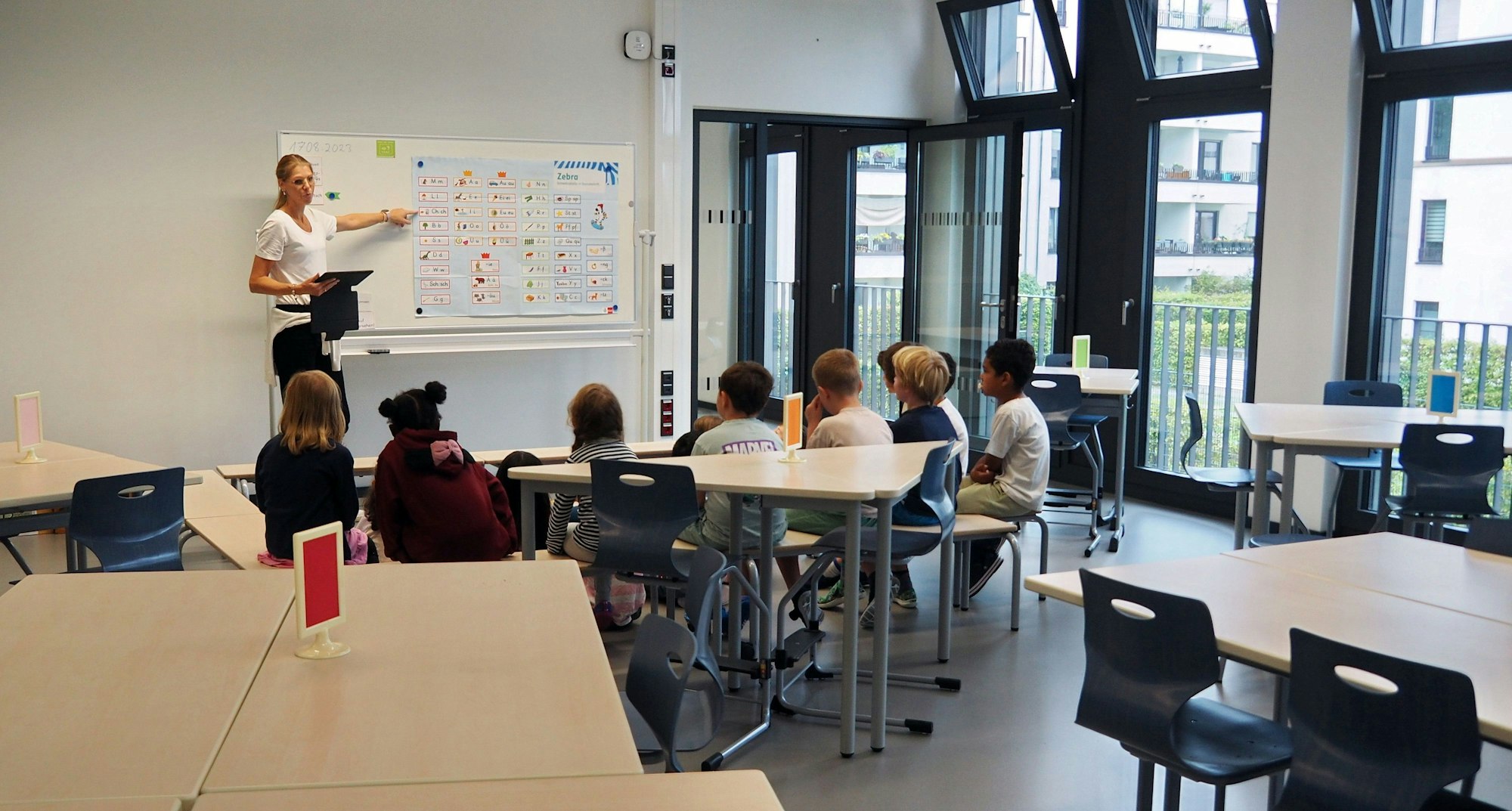 Anfang August ging eine neue Grundschule in der Gaedestraße an den Start. Auf dem Foto sind eine Lehrerin und Kinder beim Unterricht zu sehen.