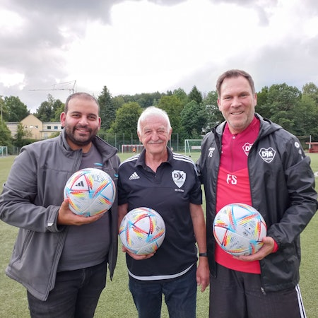 Zu sehen sind drei Männer, die jeweils einen Fußball in der Hand halten.