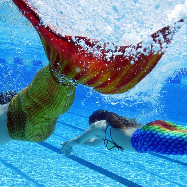 Im Freibad „Sonnenbad“ in Karlsruhe (Baden-Württemberg) schwimmen Teilnehmer des dritten baden-württembergischen Meerjungfrauen-Treffen durch das Wasser des Beckens