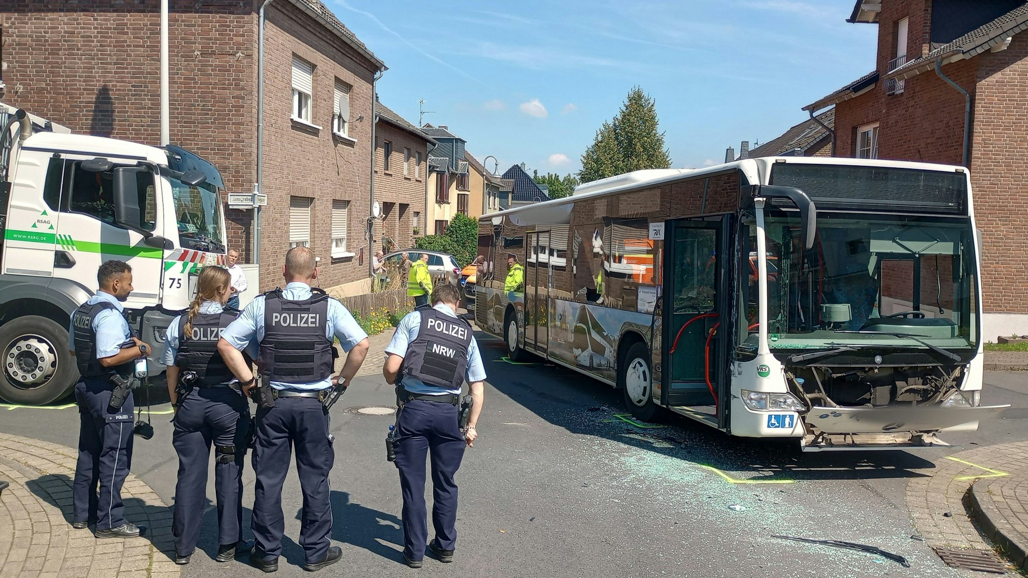 An einer Unfallstelle in Bornheim stehen ein Bus und ein Müllwagen.
