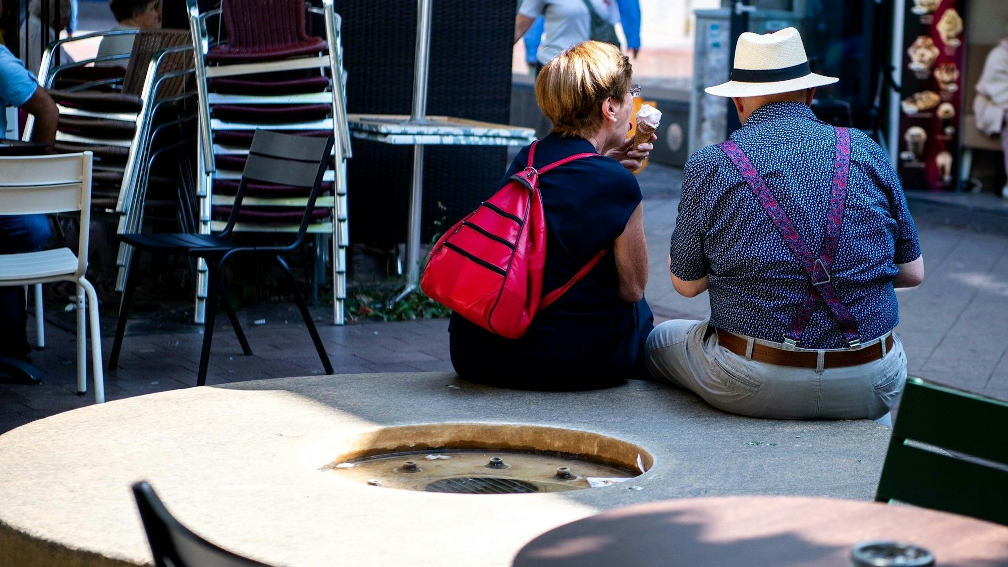Ein Mann und seine Frau sitzen in der Euskirchener Innenstadt und essen ein Eis.