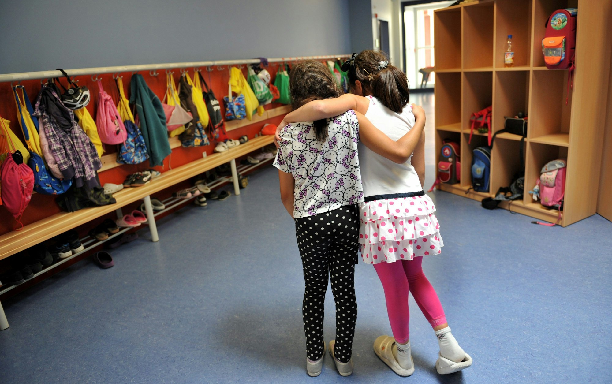 Zwei Grundschulkinder Arm in Arm.