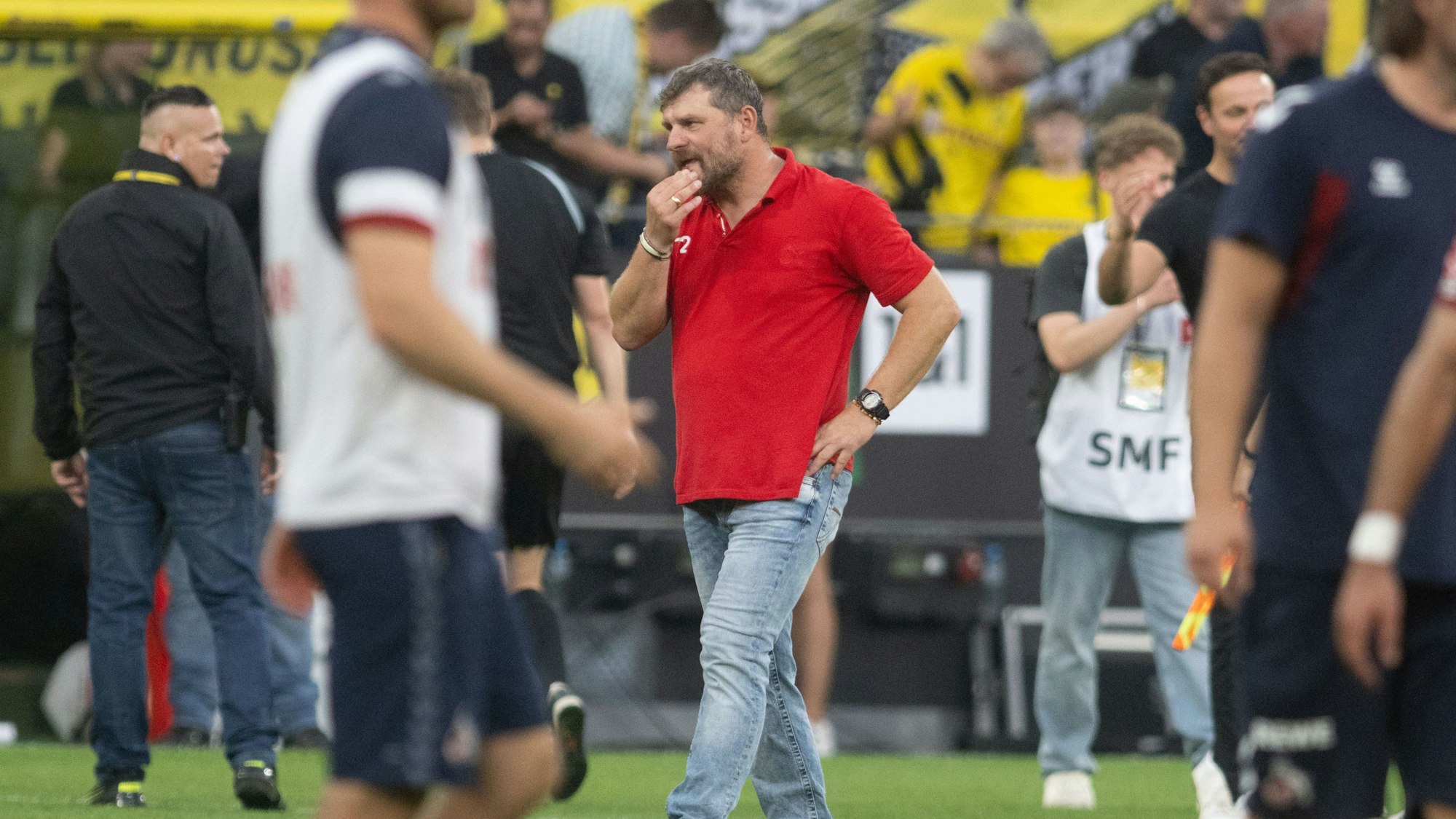 Kölns Trainer Steffen Baumgart geht ohne seine berühmte Schiebermütze über den Platz.