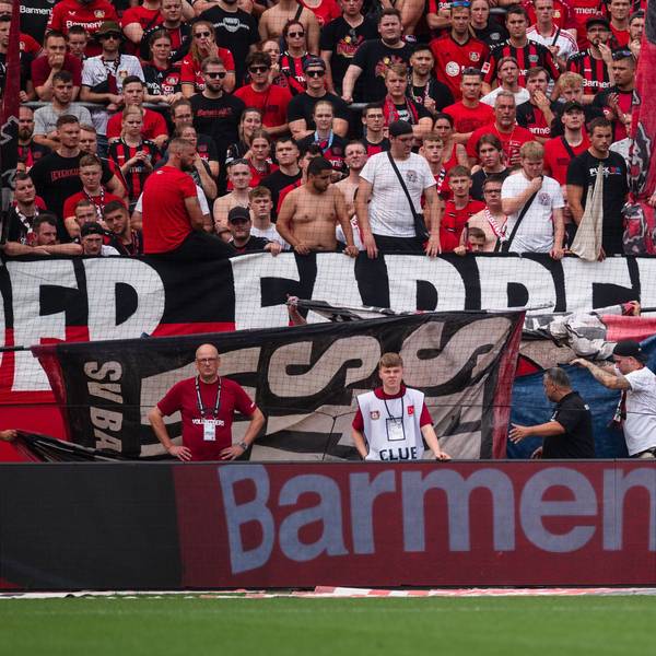 Abgeschirmt von Fan-Flaggen wird ein verletzter Zuschauer aus dem Stadion gebracht.