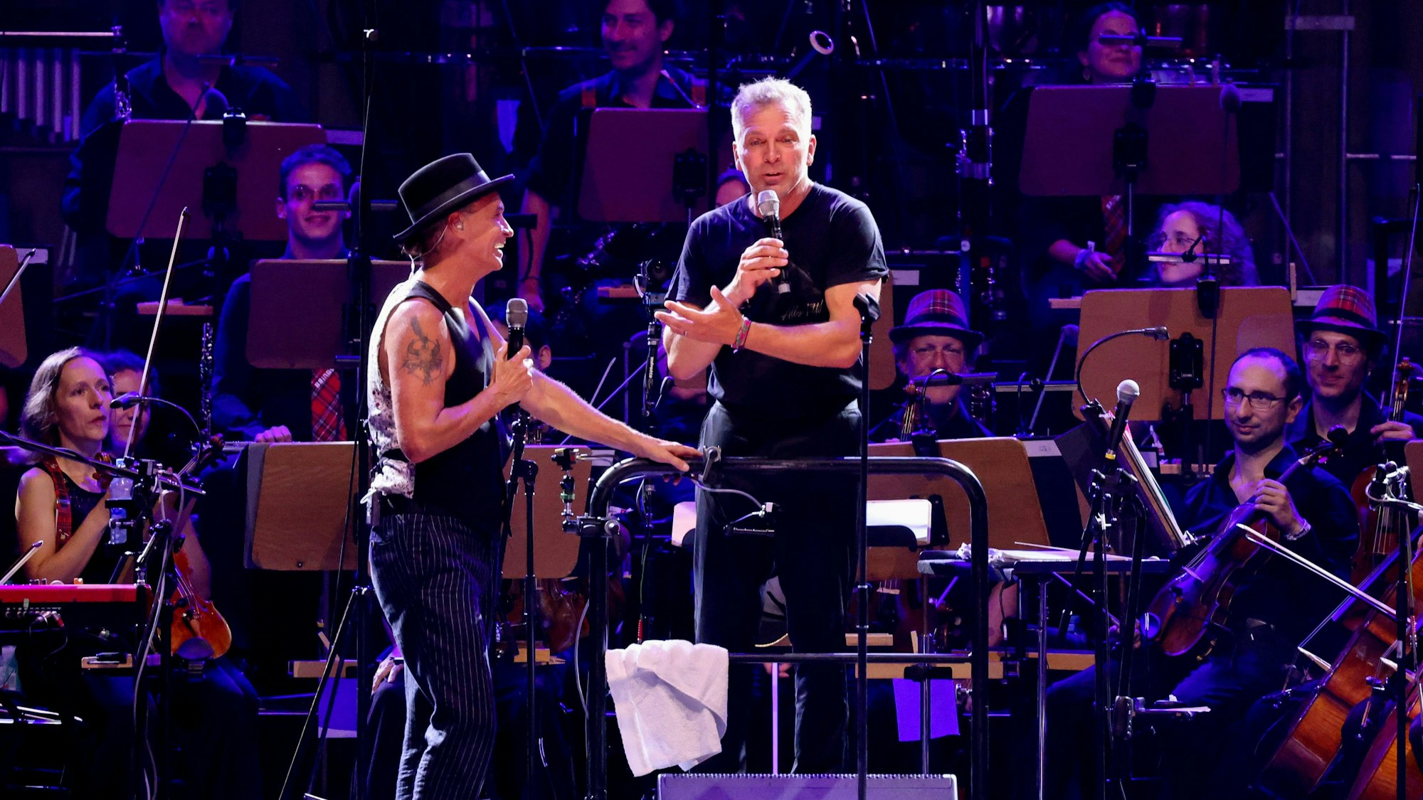 18.08.2023, Köln: Die Kölner Band BRINGS und das Beethoven Orchester Bonn spielen ein Konzert auf dem Roncalliplatz vor dem Dom in Köln - Peter Brings mit Orchester Dirigent Dirk Kaftan. Foto: Thilo Schmülgen