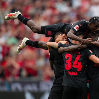 Leverkusens Jeremie Frimpong springt nach dem Treffer zur 2:0-Führung auf den Torschützen Jonathan Tah, Granit Xhaka, Odilon Kossounou und Edmond Tapsoba (v. l.).
