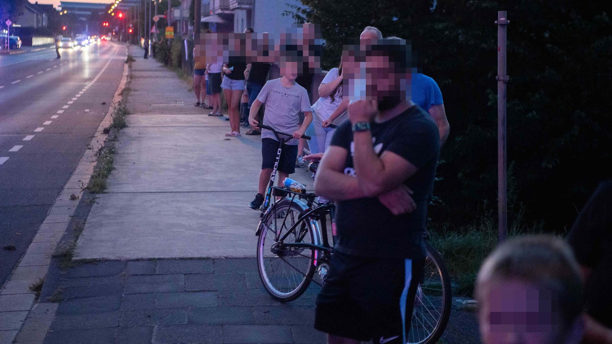 Das Bild zeigt zahlreiche Menschen, die in Richtung des Hubschraubers blicken. Einige filmen die Szenerie auch.