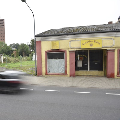 An einer Straße steht ein verfallenes Gebäude. Über dem Eingang prangt ein Schild mit der Aufschrift: "Sunshine Video".